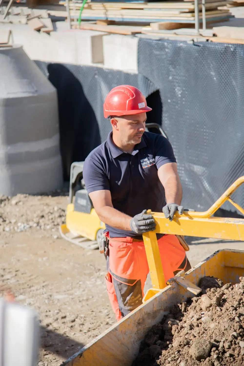 Mitarbeiter der Gebr. Bachmann AG an einer Baumaschine bei Erdarbeiten