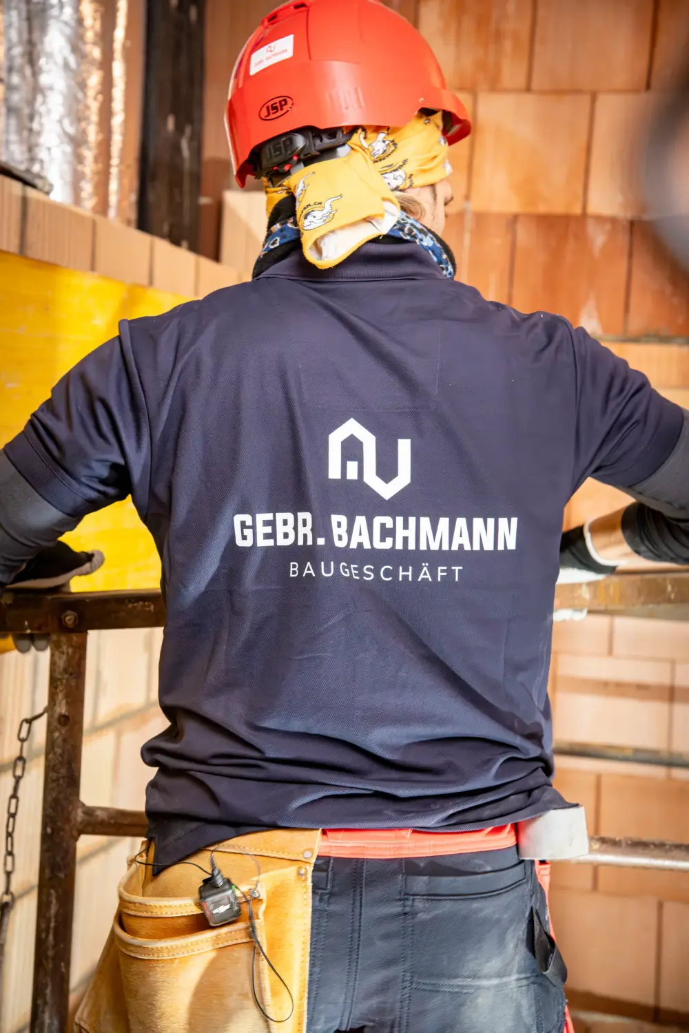 Mitarbeiter der Gebr. Bachmann AG beim Arbeiten an einer Backsteinwand