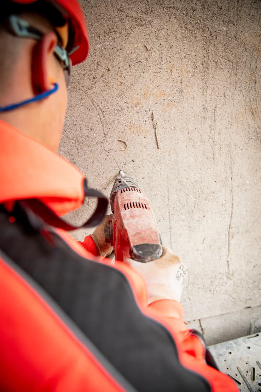 Mitarbeiter setzt eine Bohrung in eine Betonwand