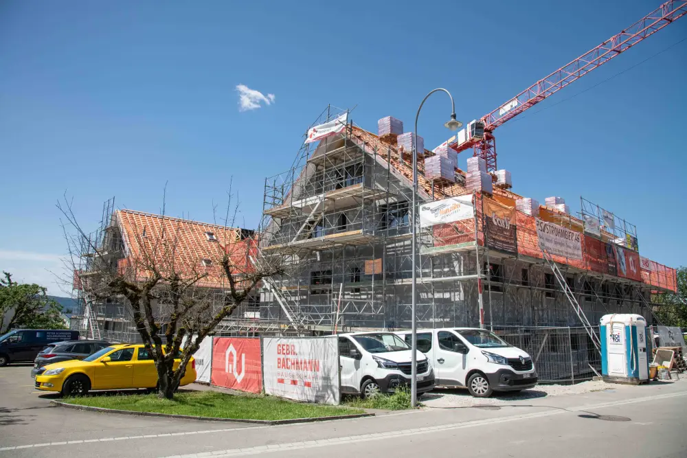 Eingerüstetes Gebäude mit Kran und Baubanner