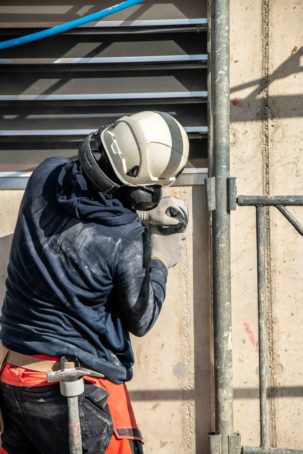 Mitarbeiter mit Atemschutz beim Trennschnitt in einer Betonwand