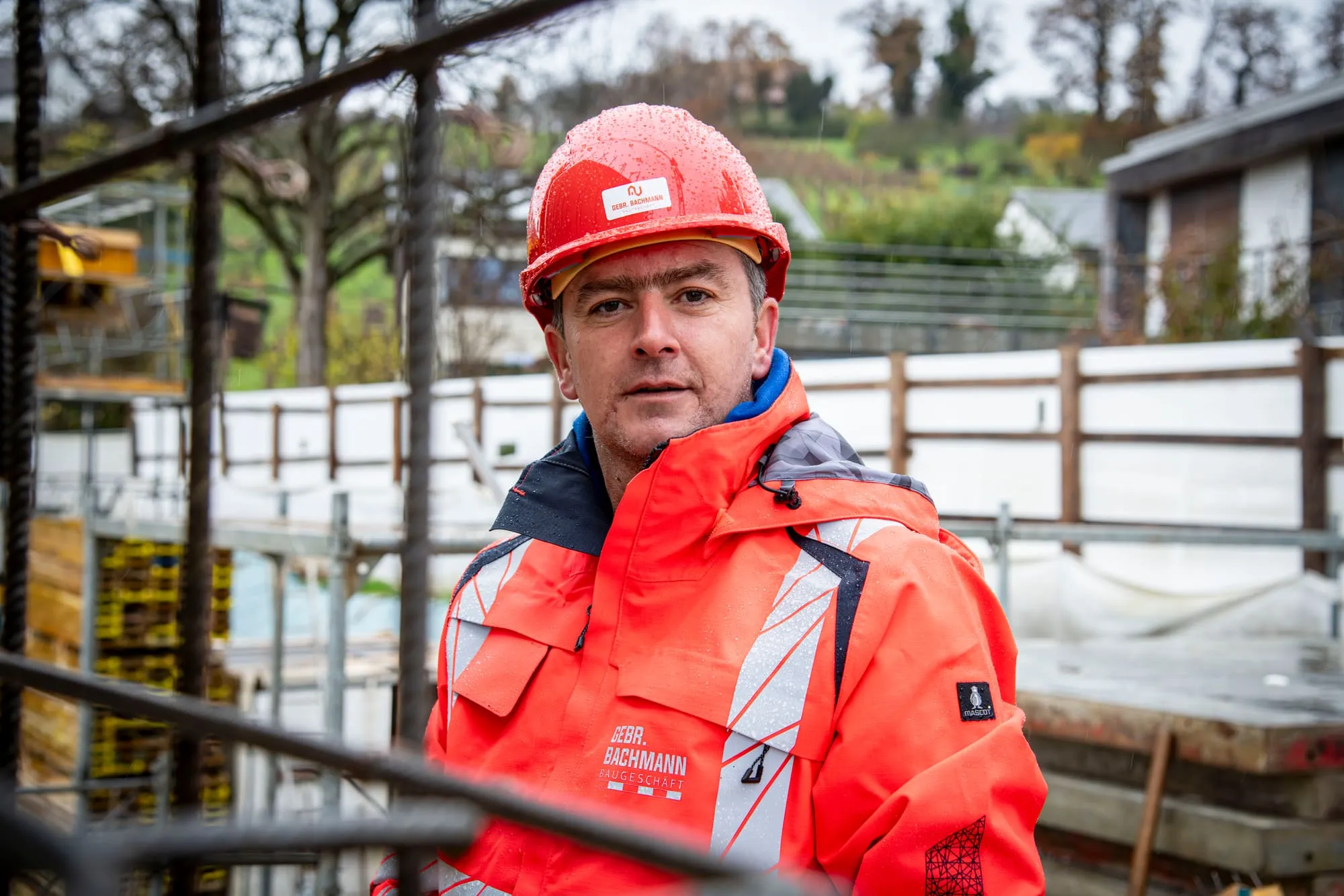 Polier der Gebr. Bachmann AG mit rotem Helm auf der Baustelle