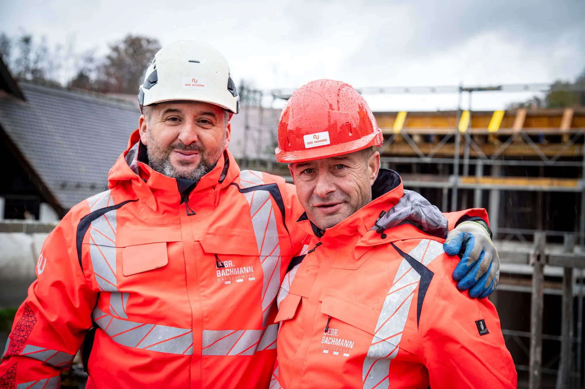 Zwei Mitarbeiter der Gebr. Bachmann AG Arm in Arm auf der Baustelle